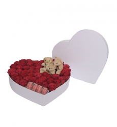 Beyaz kalp kutu içerisinde kırmızı güller, makaronlar ve mini ayıcıklar ile hazırlanmıştır.